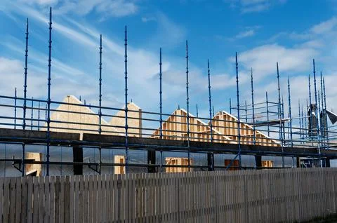 Scaffolding surrounding house development for safe access to construction work Stock Photos
