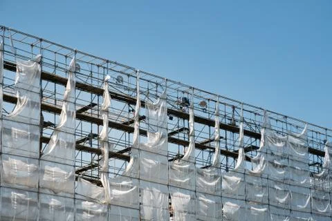 Scaffolding with white canvas and blue sky background Stock Photos