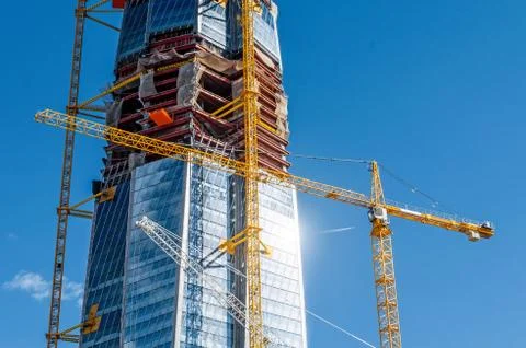 Scale active skyscraper building, glare from the sun on the windows, cranes a 스톡 사진