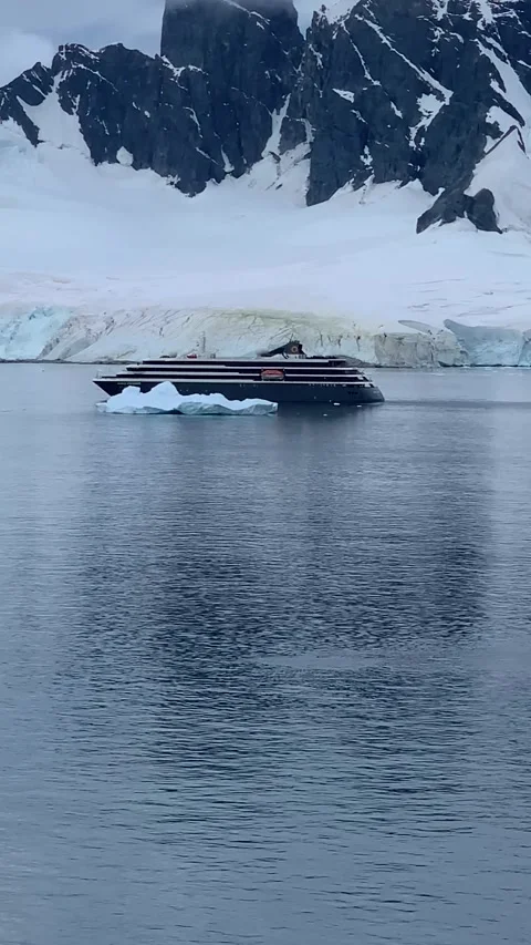 Scale Comparison: World Explorer Ship Passing Massive Iceberg in Antarctica Video stock 330035480