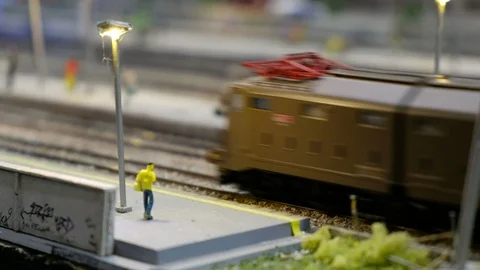 Scale model making train toy representing man waiting platform with two trains Stock Footage 123690959