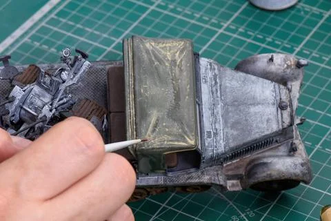 Scale Modeling. A man make Weathering on the roof of the cab. Stock Photos