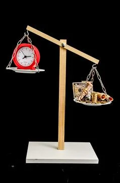 A scale with a red clock on one side and a pile of money on the other Stock Photos