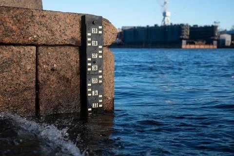 Scale of water level indications in the river. Stock Photos
