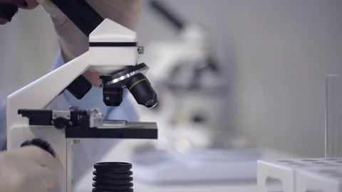 Scaled up view on scientist looking through microscope Stock Footage 80356310