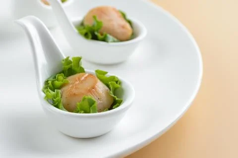 Scallop snack on spoon Stock Photos