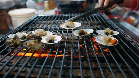 Scallops on a bbq grill. A vendor is grilling seafood over charcoal fires a.. Stock Footage 336982615