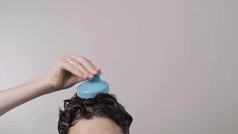 Scalp brush in the shower, dark-haired girls top of head in thick shampoo foam, Stock Footage 281577280