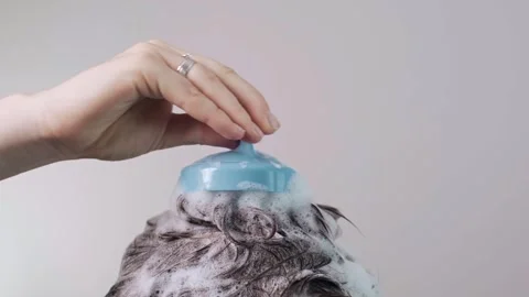 Scalp brush in the shower, dark-haired girls top of head in thick shampoo foam, Stock Footage 281577281