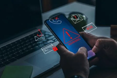 Scam call sms message received on smartphone during work hours in a home office Stock Photos