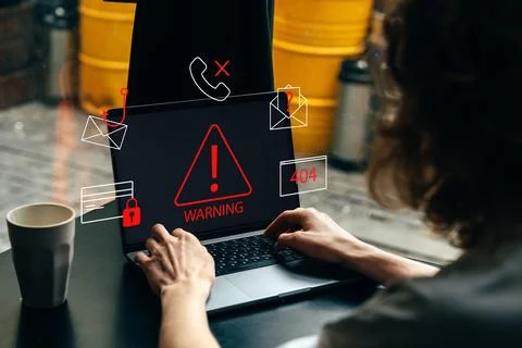 Scam call sms message warning on a laptop screen during a work session at a cafe Stock Photos