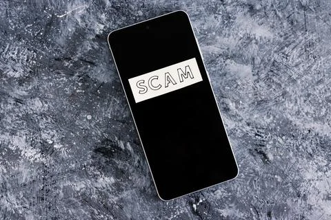 Scam calls and personal data theft, smartphone with text on it on dark backgr Stock Photos