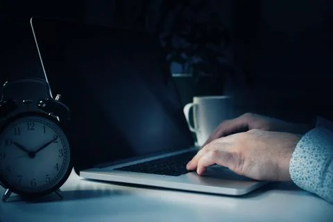 Scam message received while working late at night with coffee and clock on table Stock Photos