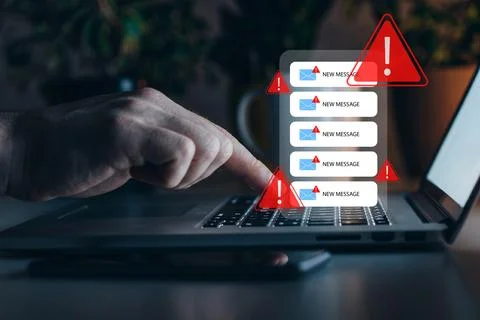 Scam message warning appears on laptop screen while user checks inbox at home Stock Photos