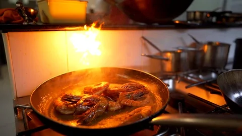 Scampi flambe by chef in kitchen Stock Footage 128569315