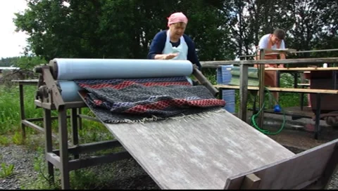 Scandinavia Finland housewife cleaning carpet in open-air cleaning facility Stock Footage