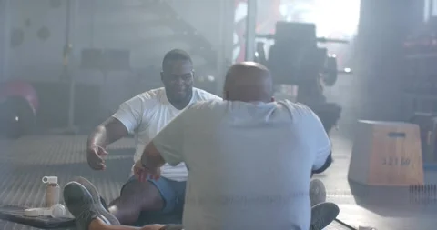 Scanlines clearing, revealing two men performing partner situps on gym mats for Stock Footage 330888134