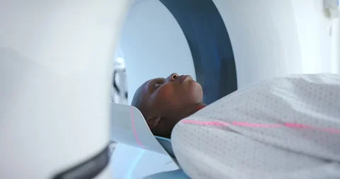 Scanner table is moving into gantry as machine is starting head scan, showing Stock Footage 344948688