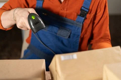 Scanning barcode on delivery parcel. Worker hands scan barcode of cardboard p Foto stock