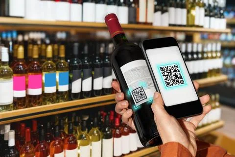 Scanning e-label of wine bottle by smart phone in liquor store. Foto stock