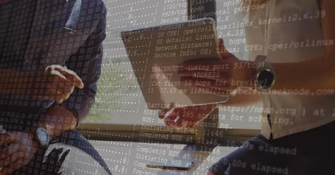 Scanning network on tablet by two IT consultants wearing casual shirts by blinds Stock Photos