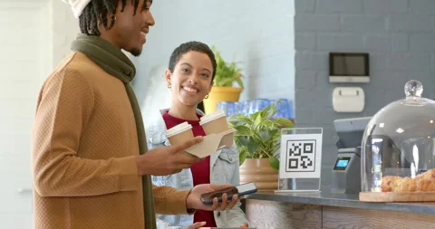Scanning QR code Diverse couple tapping smartphone at coffee counter paying and Vídeo Stock 336535473