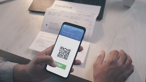 Scanning QR code on an invoice and paying with mobile wallet app Stock Footage 154003932