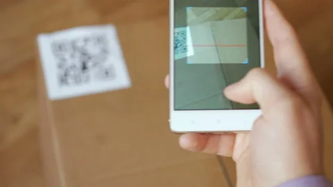 Scanning QR code with smart phone. The man reads the bar code using the appli Stock Footage 100724961