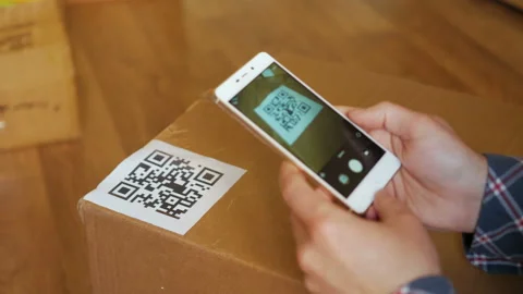Scanning QR code with smart phone. The man reads the bar code using the appli Stock Footage 100724964
