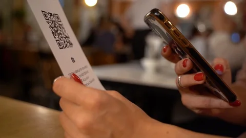 Scanning QR code with smart phone. The woman reads the bar code using the Stock Footage 117348657