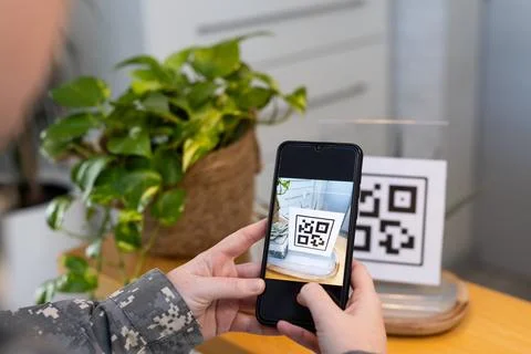 Scanning QR code with smartphone, person in medical clinic setting Foto stock
