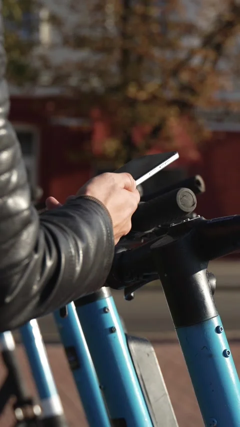 Scanning a QR code with a smartphone to rent an electric scooter.  Stock-Footage 346018952