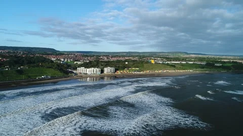 Scarborough drone high over the waves towards North Bay Stock Footage 240950832