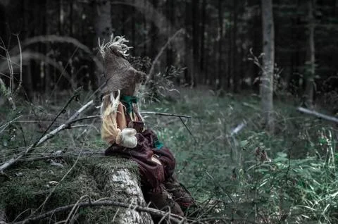 Scarecrow sitting alone on a tree trunk Stock Photos