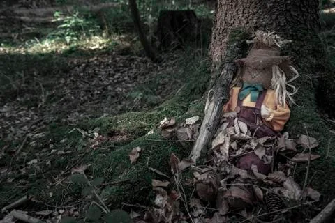 Scarecrow sitting at the root of a tree Stock Photos