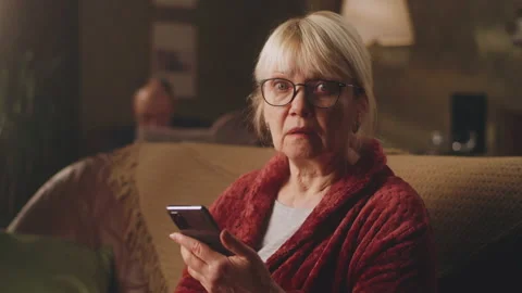 Scared aged woman reading shocking news Stock Footage 172043699