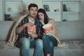 The scared couple eating popcorn and watch a horror movie on the sofa Photo