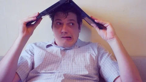 Scared crazy man sits covering his head with a laptop Stock Footage 86166835