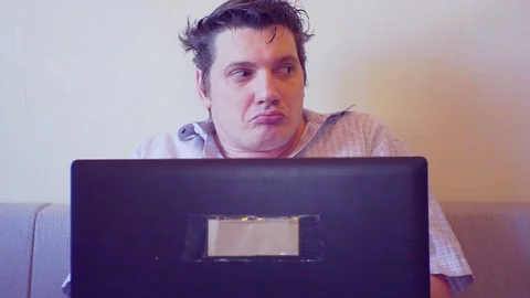 Scared crazy man sitting with laptop looking around Stock Footage 86165398
