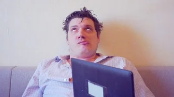 Scared crazy user sitting with laptop on head Stock Footage 86164042