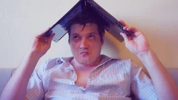 Scared crazy user sitting with laptop on head Stock Footage 86166522