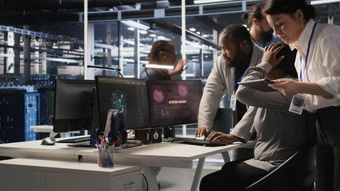 Scared data center technicians reacting to virus warning on PC display, running Stock Photos