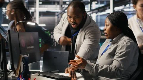 Scared data center technicians reacting to virus warning on PC display, running Stock Photos
