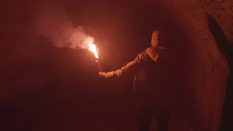 Scared Digger Guy with Red Flare Torch walking through Medieval Dungeon Tunnel Video stock 170726856