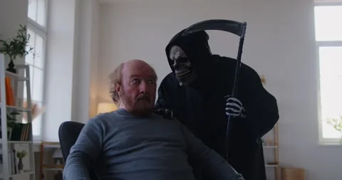 Scared elderly man feeling proximity of death while grim reaper figure leaning Video stock 308563756