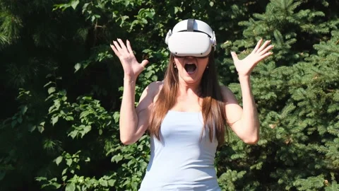 Scared female in virtual reality glasses screams in horror from the fear of what Stock Footage 168176148