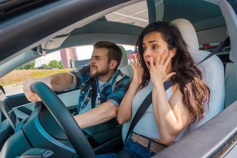Scared instructor screaming sitting in the car and taking exam in young woman Foto stock