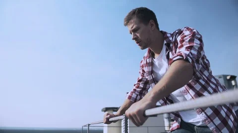 Scared male looking down standing rooftop, fear of heights, problem hopelessness 動画素材 117217722