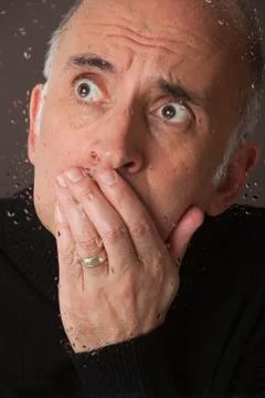 Scared man behind a glass window Stock-Fotos