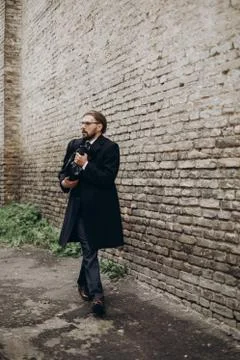 Scared man embracing bag while walking outdoors Stock Photos